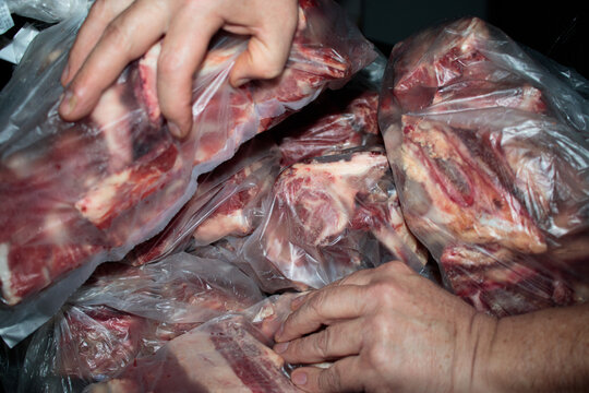 Unrecognizable Person Handling Packaged Beef Cuts