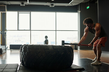 Man During Sledgehammer Workout in Gym