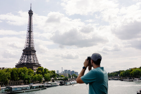 Blurred foreground of a tourist taking photos of the Eiffel Tower 