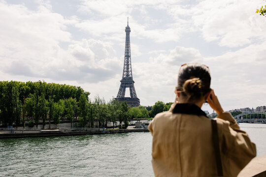 Female tourist taking photos of the Eiffel Tower in Paris