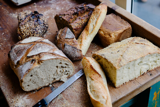 Cutting board with various types of sliced bread and a bread knife