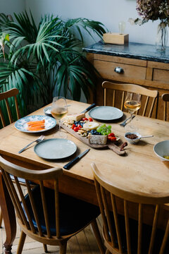 A rustic dining table in a Parisian loft, set with a cheese board