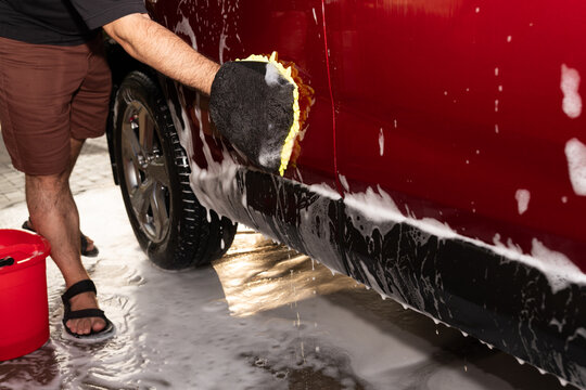 Cleaning a Red Vehicle With Soap and Sponge 