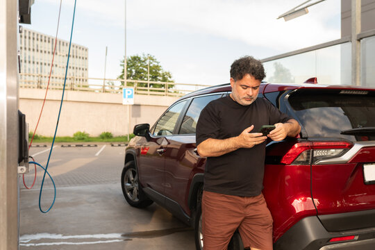 Man Using His Phone at Self-Service Car Wash 