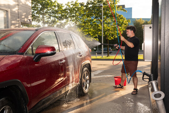 Man Washing His Vehicle Outdoors in Daylight