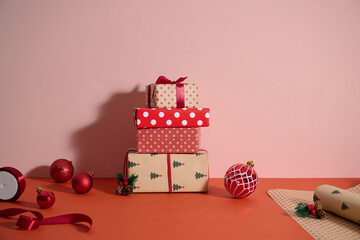 A stack of beautifully wrapped Christmas gifts with ornaments