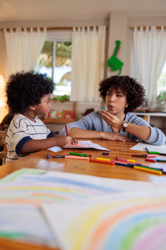 Child and adult coloring together at a table.
