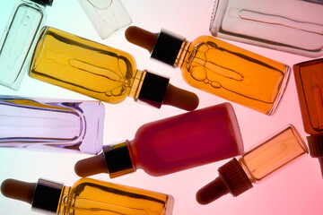 Many Colorful Cosmetic Bottles With Droppers on a Vibrant Background