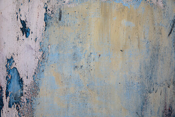 Close-up of a weathered, textured surface with layers of blue and pink