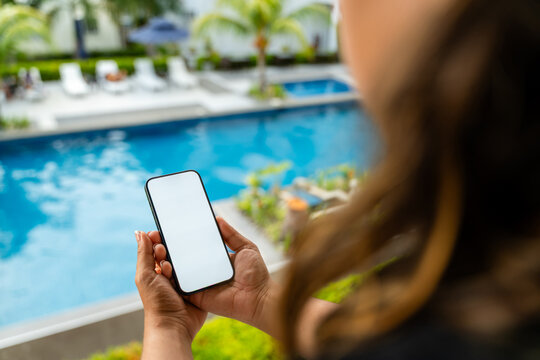 Woman holding a phone by the pool
