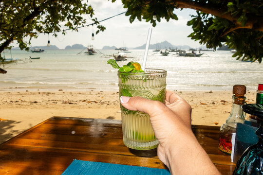 Woman holding refreshing mojito cocktail 
