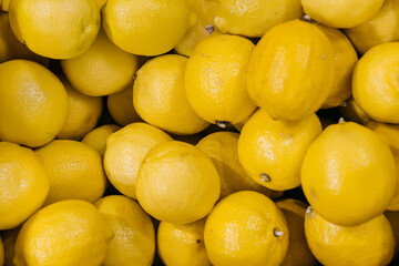 Fresh yellow lemons piled together, showcasing their vibrant color and smooth texture, representing healthy eating and natural ingredients in culinary applications