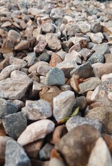Curated image of pile of rocks and stones of various sizes and colors in natural light.