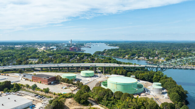Aerial views of Interstate 95 crossing the Piscataqua River Bridge with traffic, storage tanks, marina, and surrounding landscape.