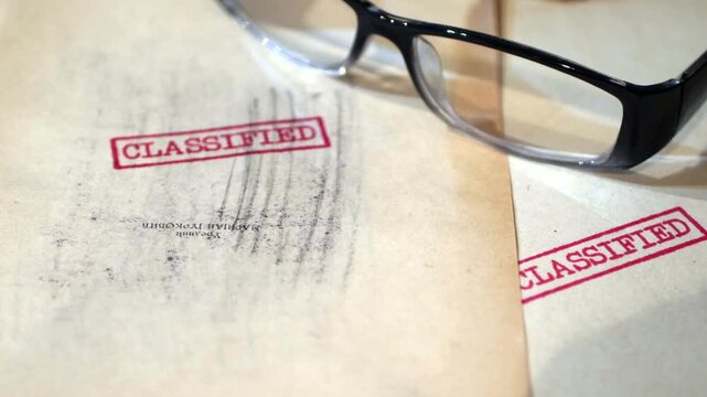 An old  sensitive documents and secret information with the stamp CLASSIFIED dolly shot