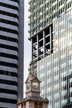 Clock tower framed by modern skyscrapers