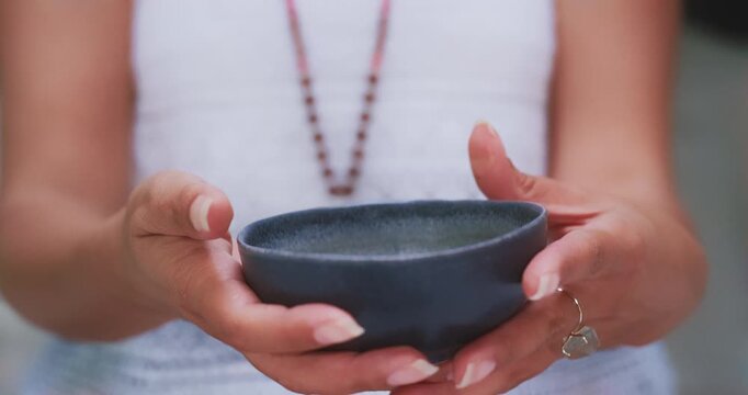 Focus pull on tea cup held by elegant hands, close-up