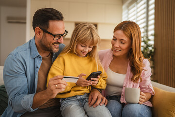 Happy family making online payment using credit card and smart phone