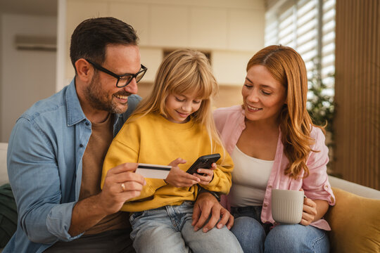 Happy family making online payment using credit card and smart phone