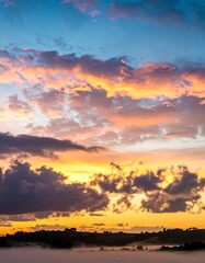 A vibrant sunset over a misty landscape