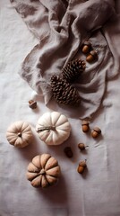 Obraz premium Warm autumn flat lay with pumpkins, pinecones, acorns and rustic fabric. Cozy seasonal decoration.