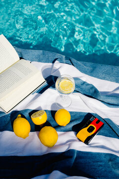 Flatlay of an open book, a glass of lemonade, a camera, and lemons