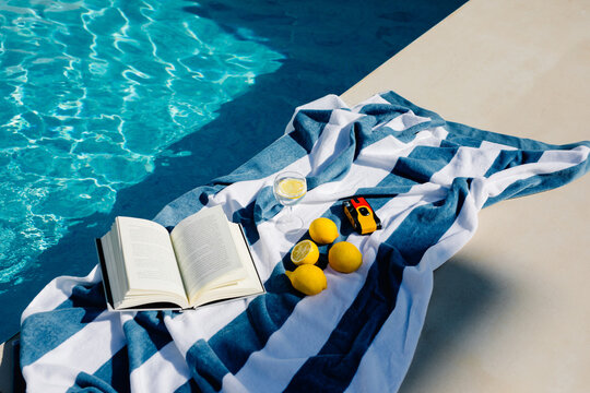 Still life of a book, lemonade, a camera and lemons on a towel