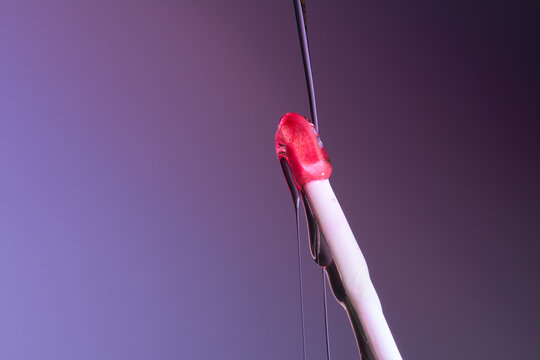Purple lip gloss brush close up with a liquid flowing down