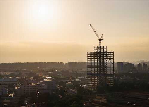 Urban construction with crane at sunset cityscape