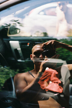 Man takes a photo in the reflection of a car