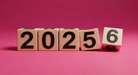 Wooden blocks with the year 2025 falling over to reveal the number 6, symbolizing the transition to the next year.