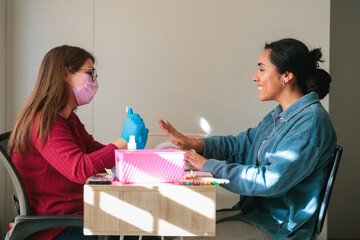 Smiling client interacting with manicurist during nail appointment