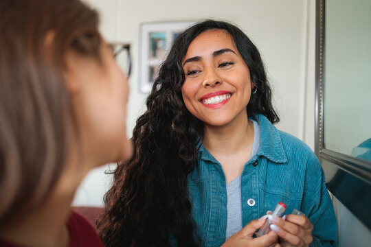 Latina Woman Smiling While Chatting with Her Friend