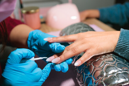 Final gel coat being applied to almond-shaped nails