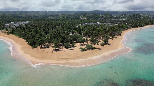 Aerial footage of Punta Popy Beach &mdash; wide beach view with blue sky and calm ocean. Ideal for vacation campaigns