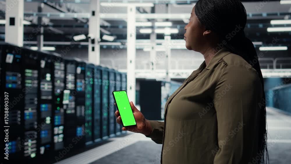 Wall mural software developer using app on mockup phone to check server hub energy consumption. african america