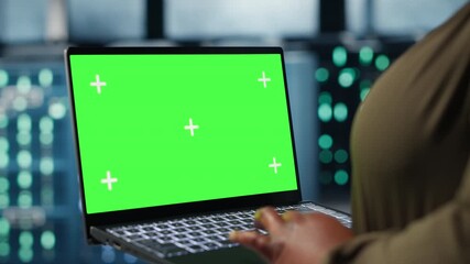 Close up of admin working in data center using green screen laptop to optimize network infrastructure. Server farm worker diagnosing and resolving hardware malfunctions using chroma key notebook