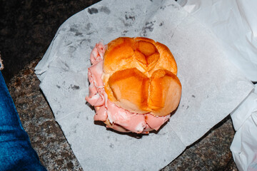 a rosetta sandwich with mortadella seen from above on stone