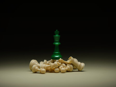 A green king rises victoriously over defeated white chess pieces