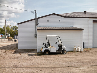 White Golf Cart Parked Beside Industrial Building in Elbow Saskatchewa