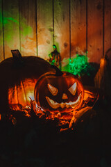 Halloween terrible pumpkin Jack with green smoke in the dark close-up.Autumn festive atmosphere....