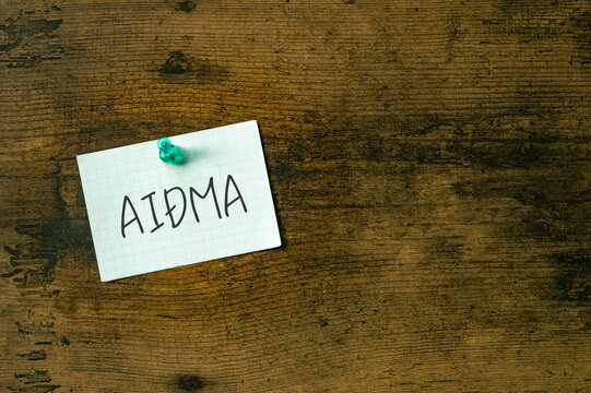 There is a piece of paper with the word AIDMA. It is an abbreviation for Attention, Interest, Desire, Memory, Action as eye-catching image.