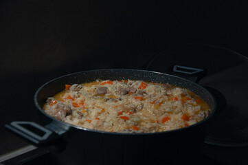 Traditional pilaf with rice and meat in pot