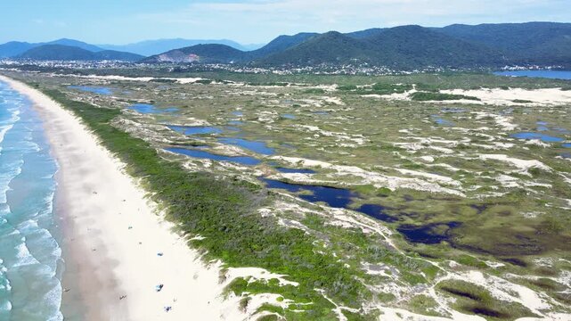 Aerial view of the dunes of Joaquina Beach in Florianopolis, Santa Catarina, Brazil. Lagoa da Concei&ccedil;&atilde;o Natural Park, a restinga and permanent preservation area