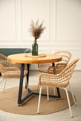 Wooden table with decor and stylish chairs in dining room