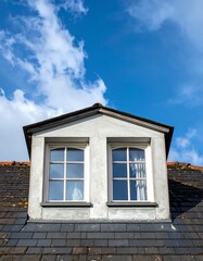 A quaint attic window against a vibrant sky