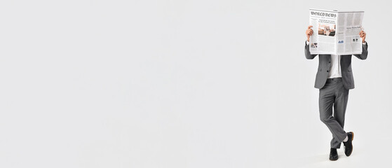 Young businessman reading newspaper on white background