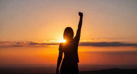 Silhouette of a triumphant person raising their fist against a vibrant sunset sky