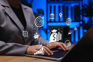 Financial Technology and Money Management Concept. Businesswoman working on laptop with icons representing online banking, digital money, investment growth, savings, transaction, financial technology