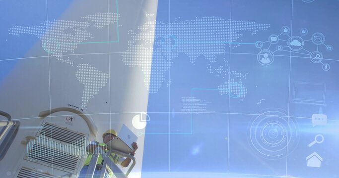 Technician in helmet vest inspecting wind turbine with tablet at farm with data overlay, copy space